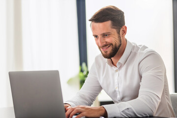 Successful businessman working using computer laptop sitting at the workplace in modern office....