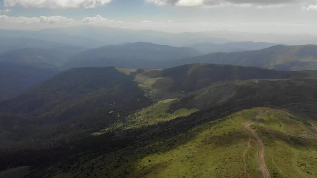 Following paraglider flying above carpathian mountains. Drone footage 4K. Ukraine.