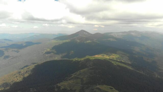 Following paraglider flying above carpathian mountains. Drone footage 4K. Ukraine.