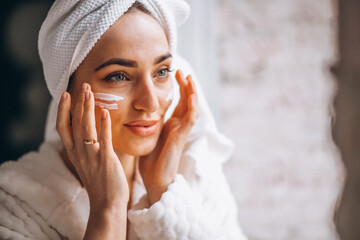 Woman applying moisturizing face cream