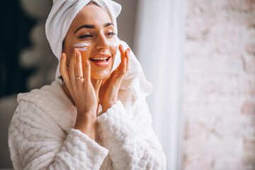 Woman applying moisturizing face cream