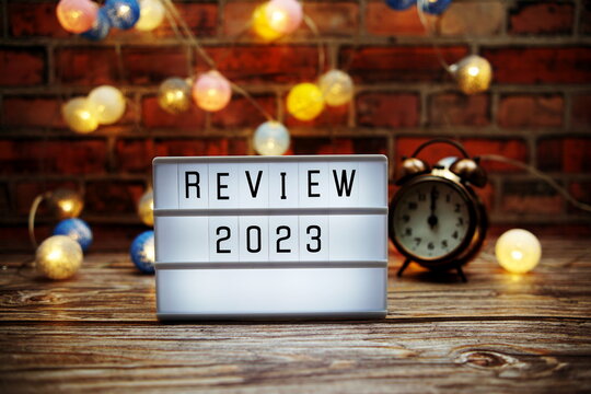 Review 2023 text in light box with alarm clock and LED cotton balls decoration
