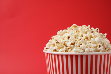 Delicious popcorn on red background, closeup. Space for text