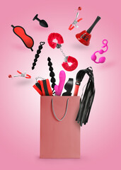 DIfferent sex toys and accessories falling into paper shopping bag on pink background