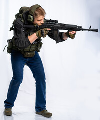 Combat soldier armed special forces player in noise isolation headphones storms, goes on the attack. A soldier with a machine gun moves forward and covers the surroundings.