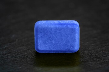 blue rectangular pill on black background