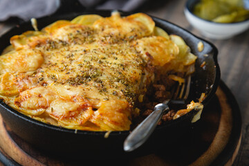 Potato casserole with meat and cheese in a frying pan