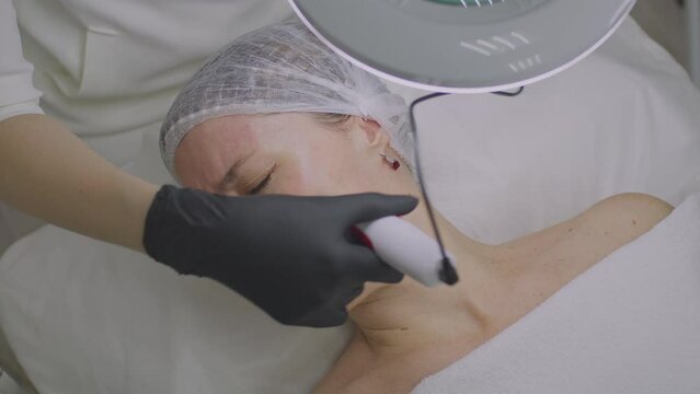 Close-up of a woman face. Needle mesotherapy procedure into the skin of the face