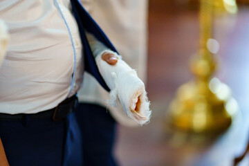 a man with a broken arm in a cast in the church at baptism