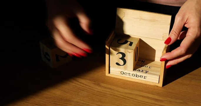 Woman hand change, sets the date on the wooden calendar on 31 October , Thanksgiven day, Halloween, hard light, sunlight,