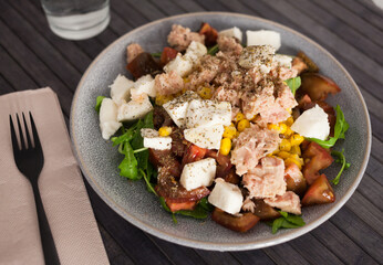 Plate of salad with tuna, corn, tomatoes and arugula