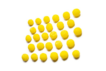 a lot of yellow round candies are laid out in a row on a white background