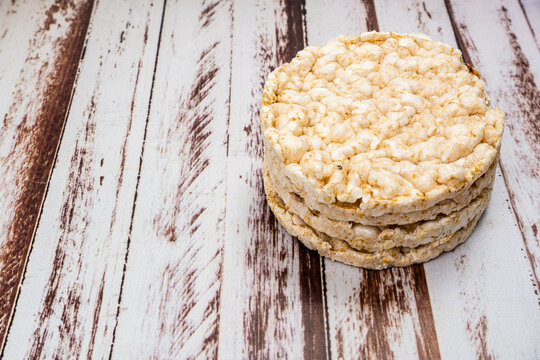 Round rice crackers on a rustic wooden table. Copy space. Healthy, natural food. Vegan food.