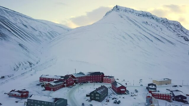 Aerial view of Longyearbyen in winter, Svalbard. With colorful houses, snow-capped mountains, with avalanche protection and old towers. for transporting coal.