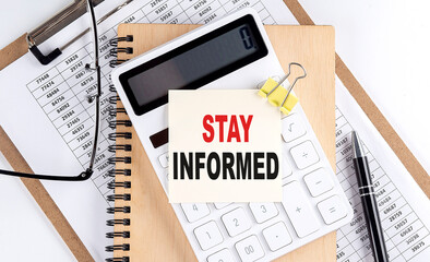 STAY INFORMED word on sticky with clipboard and notebook, business concept