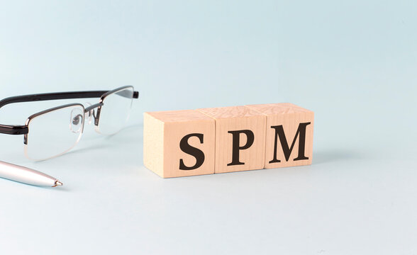 Text SPM - Sales Performance Management - written on the wooden cubes on blue background