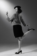 Portrait of beautiful woman in character of famous fashion designer posing in stylish classic suit. Black and white photography. Femininity