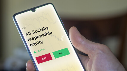 An investor's analyzing the all socially responsible equity etf fund on a screen. A phone shows the prices of all socially-responsible equities ESG ETF