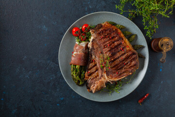 Grilled, medium-baked t-bone beef steak. Served with asparagus.