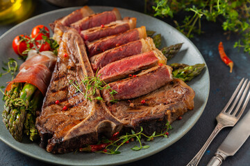 Grilled, medium-baked t-bone beef steak. Served with asparagus.