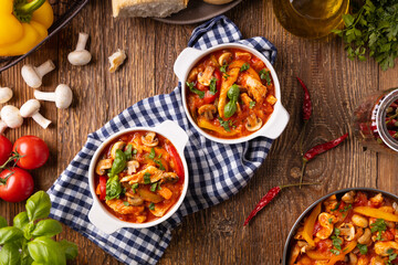 Fototapeta na wymiar Chicken stew with peppers, mushrooms and tomatoes.