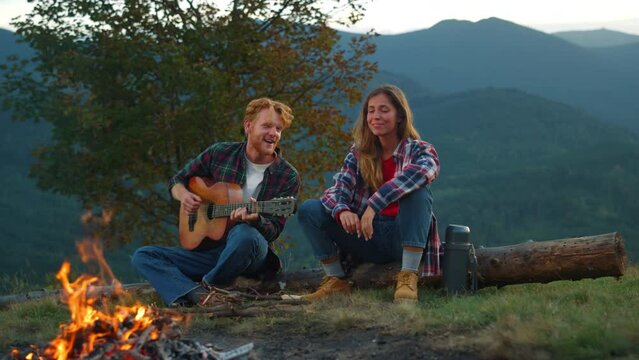 Two campers rest outdoors in mountains. Happy couple spend vacation closeup.