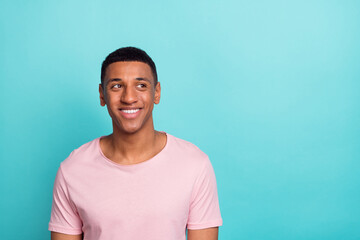 Photo of sweet attractive young guy wear pink t-shirt smiling looking empty space isolated teal color background