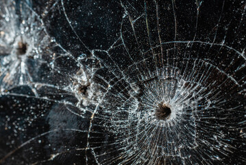 Bullet hole in a glass on the black background.closeup.