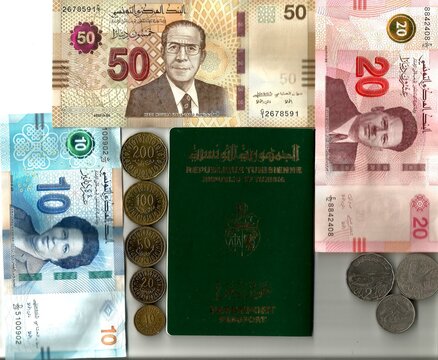 A Tunisian green Passport surrounded by local banknotes and coins in Dinar
