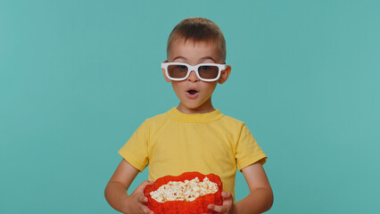 Little toddler children boy in t-shirt eating popcorn and watching comedy movie film wearing 3D...