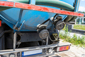 A truck with a large tank for pumping out a septic tank, visible closed flange connection.