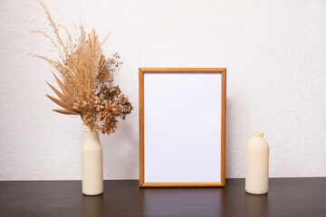Mock up empty wooden frame mockup, dried leaf and pampass grass in vase on white background,...