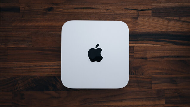 LONDON - AUGUST 3, 2022: Apple Mac Mini computer top view on wood office desk background