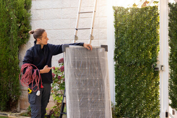 Young electrician pointing a solar apnel to be installed and have solar power. Wire, stairs and...