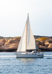 Sailboat sailing in golden hour light outside of Lysekil on the Swedish west coast