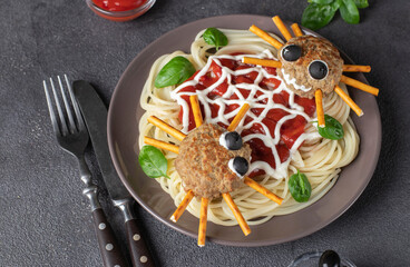 Cutlets look like a spiders with olives and straws, served with spaghetti pasta and tomato sauce....