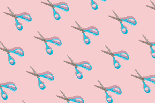 Blue scissors trendy pattern on bright pink background. Minimal flat lay conceptual style. Sunny day shadows.