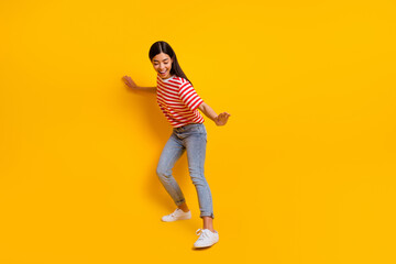 Fototapeta na wymiar Full body portrait of overjoyed lady dancing partying toothy smile isolated on yellow color background