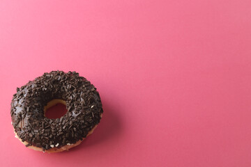 High angle view of fresh donut with chocolate sprinklers by copy space on pink background - Powered by Adobe