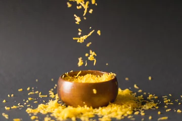 Foto op Plexiglas Grated yellow cheese and bowl against gray background, copy space © WavebreakMediaMicro