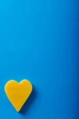 Foto auf Acrylglas Directly above shot of heart shaped yellow cheese on blue background, copy space © wavebreak3
