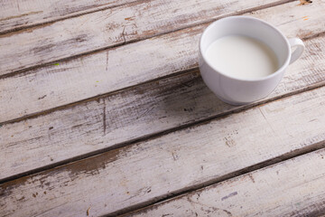 Fototapeta na wymiar High angle view of milk in cup on wooden table, copy space