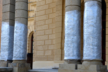 a sandstone pillar made of sandstone blocks in the shape of a cylinder, wrapped in shrink wrap to protect the plaster when moving things into the museum through the main entrance.