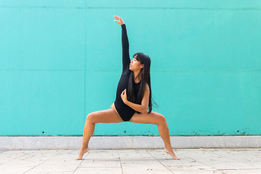 Asian ballerina doing plie squat on street
