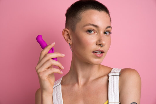 Short haired woman posing to the camera with vibrator for clitoral vaginal stimulation