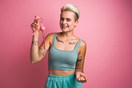 Tempting tattooed girl posing with pink silicone ball gag for her mouth