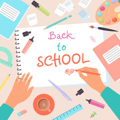 Top view of desk with human hands drawing in notebook. Back to school. Colorful set of school supplies arranged on a desk from top view.