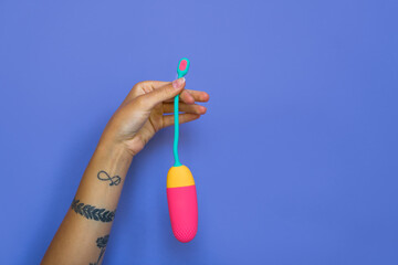 Woman hand holding latex vaginal egg vibrator for training the pelvic floor muscles with an antenna