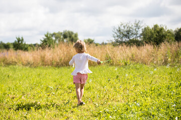 Beautiful little girl, has happy fun cheerful smiling face, soap bubble blower.