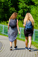 Two girlfriends walk along a path in the Park

